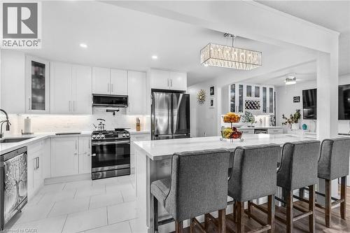 Kitchen with glass insert cabinets, appliances with stainless steel finishes, white cabinetry, light stone counters, and recessed lighting - 136 Limpert Avenue, Cambridge, ON - Indoor Photo Showing Kitchen With Upgraded Kitchen