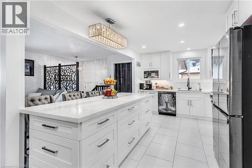 Kitchen with white cabinetry, freestanding refrigerator, open floor plan, light stone countertops, and dishwasher - 136 Limpert Avenue, Cambridge, ON - Indoor Photo Showing Kitchen With Upgraded Kitchen