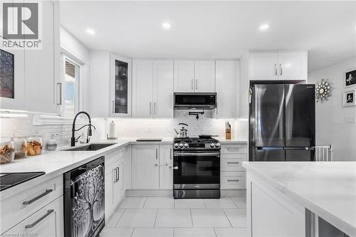 Kitchen featuring appliances with stainless steel finishes, white cabinets, light stone countertops, recessed lighting, and light tile patterned flooring - 136 Limpert Avenue, Cambridge, ON - Indoor Photo Showing Kitchen With Upgraded Kitchen