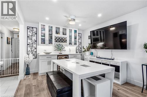Kitchen featuring white cabinets, glass insert cabinets, light wood-style flooring, light stone countertops, and wine cooler - 136 Limpert Avenue, Cambridge, ON - Indoor
