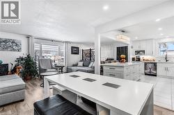 Kitchen featuring open floor plan, a center island, white cabinets, black dishwasher, and a breakfast bar area - 