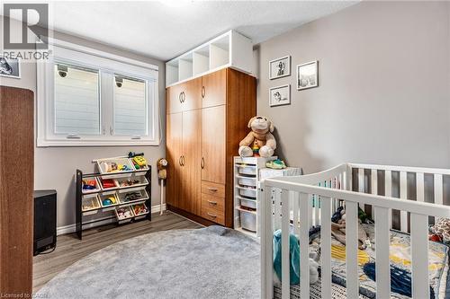 Bedroom featuring a closet, a nursery area, dark wood-style floors, and a textured ceiling - 136 Limpert Avenue, Cambridge, ON - Indoor Photo Showing Other Room