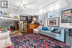 Living room featuring coffered ceiling, wood finished floors, and beam ceiling - 