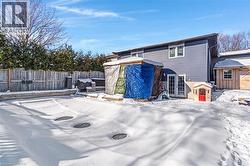 Snow covered rear of property with an outbuilding and french doors - 