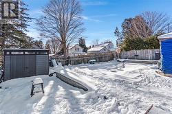 Yard covered in snow with a fenced backyard and a storage shed - 