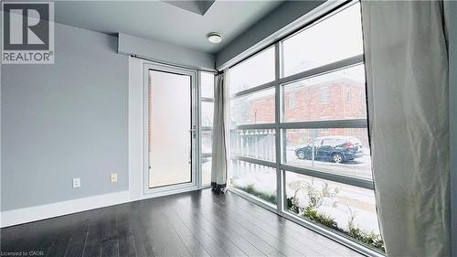 Unfurnished room featuring dark wood-style flooring and plenty of natural light - 155 St. Leger Unit# 107, Kitchener, ON - Indoor Photo Showing Other Room
