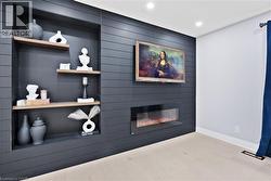 Detailed view of a large fireplace, recessed lighting, and wood finished floors - 