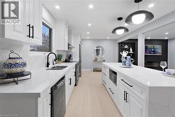 Kitchen with white cabinetry, light stone countertops, and recessed lighting - 