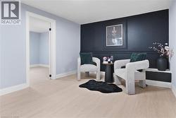 Sitting room featuring baseboards and light wood-style flooring - 