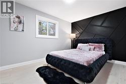 Bedroom with a decorative wall, light wood-type flooring, and an accent wall - 