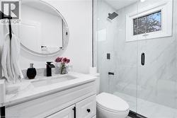 Bathroom featuring vanity and a marble finish shower - 