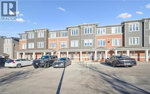 View of building exterior featuring uncovered parking and a residential view - 24 Morrison Road Unit# D9, Kitchener, ON - Outdoor With Facade