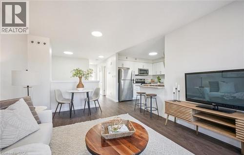 Living room with dark wood-style floors and recessed lighting - 24 Morrison Road Unit# D9, Kitchener, ON - Indoor Photo Showing Living Room