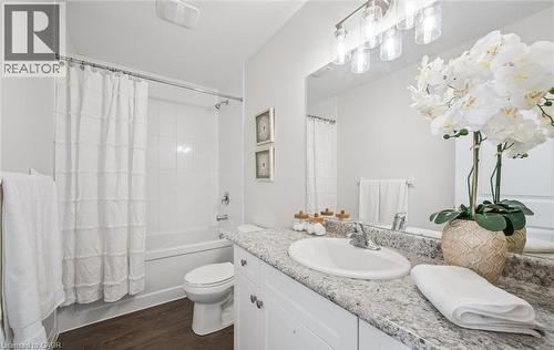 Bathroom with vanity, shower / bathtub combination with curtain, and dark wood-style flooring - 24 Morrison Road Unit# D9, Kitchener, ON - Indoor Photo Showing Bathroom