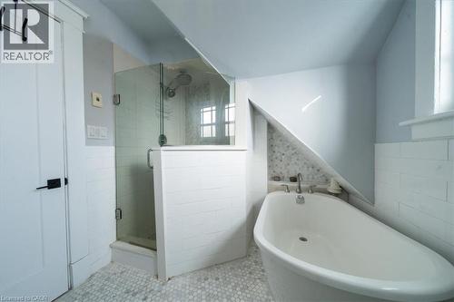 Full bathroom with tile walls, a freestanding tub, a wainscoted wall, a stall shower, and tile patterned flooring - 184 Weber Street E, Kitchener, ON - Indoor Photo Showing Bathroom