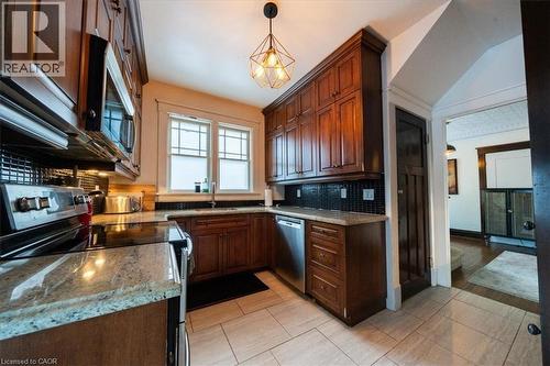 Kitchen featuring stainless steel appliances, tasteful backsplash, pendant lighting, light stone countertops, and light tile patterned floors - 184 Weber Street E, Kitchener, ON - Indoor Photo Showing Kitchen