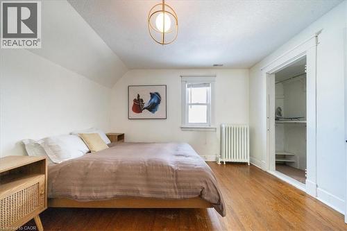 Bedroom with radiator heating unit, vaulted ceiling, wood finished floors, and a textured ceiling - 184 Weber Street E, Kitchener, ON - Indoor Photo Showing Bedroom