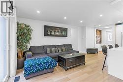Living area with light wood-style flooring and recessed lighting - 