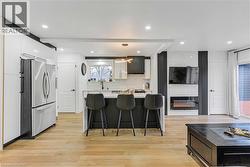 Kitchen with white cabinetry, pendant lighting, a kitchen island, freestanding refrigerator, and a breakfast bar - 