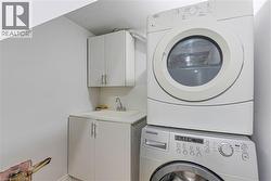 Washroom featuring stacked washer and clothes dryer and cabinet space - 