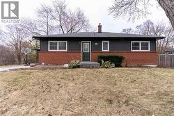 View of front of house with a chimney and brick siding - 