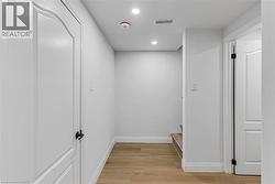 Hallway with light wood-style flooring and recessed lighting - 