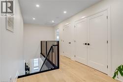 Hall featuring wood finished floors, attic access, an upstairs landing, and recessed lighting - 
