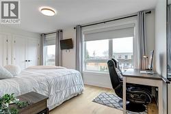 Bedroom featuring light wood-style floors and baseboards - 