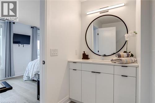 Ensuite bathroom featuring baseboards, connected bathroom, vanity, and wood finished floors - 151C Port Robinson Road, Pelham, ON - Indoor