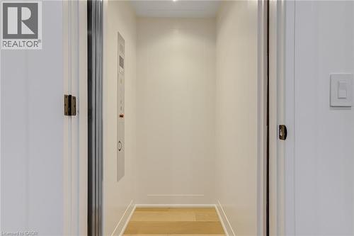 Hallway featuring elevator, baseboards, and light wood-type flooring - 151C Port Robinson Road, Pelham, ON - Indoor