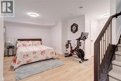 Bedroom featuring light wood-type flooring and baseboards - 
