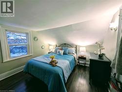 Bedroom with lofted ceiling and dark wood finished floors - 