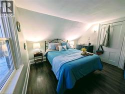 Bedroom with lofted ceiling and dark wood finished floors - 