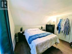Bedroom with lofted ceiling and dark wood finished floors - 