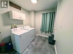 Laundry area with cabinet space, washer and clothes dryer, and vinyl flooring - 