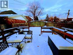 Snow covered deck featuring a fenced backyard - 