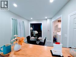 Kitchen featuring white range with electric stovetop, oak cabinets, a kitchen island, glass insert cabinets, and light vinyl floors - 