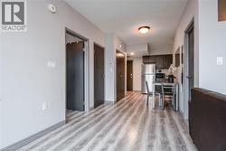 Kitchen featuring freestanding refrigerator, light wood finished floors, dark brown cabinets, and black microwave - 
