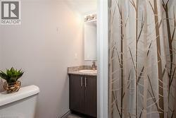 Full bath featuring toilet, vanity, and a shower with curtain - 