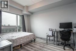 Bedroom with wood finished floors and an office area - 