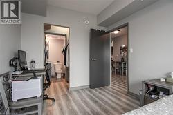 Bedroom featuring light wood-style floors, baseboards, and ensuite bathroom - 