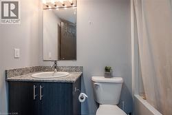 Bathroom with vanity, toilet, and shower / bath combo - 