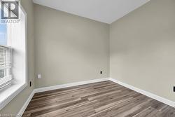 Empty room featuring wood finished floors and baseboards - 
