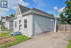 View of home's exterior featuring brick siding, a chimney, and roof with shingles - 