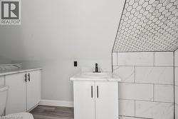 Bathroom with vanity, dark wood finished floors, and vaulted ceiling - 