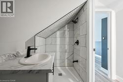 Bathroom with vanity, shower / tub combination, and wood finished floors - 