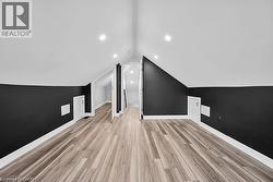 Bonus room featuring light wood-style flooring, lofted ceiling, and recessed lighting - 