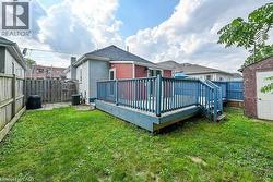 Back of property with a fenced backyard, a wooden deck, and brick siding - 