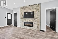 Unfurnished living room with a fireplace, recessed lighting, and light wood finished floors - 