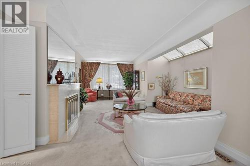 Living area featuring light carpet and a glass covered fireplace - 9 Daleview Court, Hamilton, ON - Indoor Photo Showing Other Room